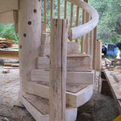 The newel post at the bottom of the stairs | Log Spiral Stairs | Handcrafted Wood LLC
