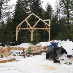 The bent is airborne briefly to align on the foundation | Timber Frame Home | Handcrafted Wood LLC