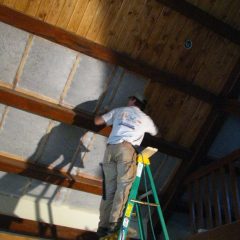 Installing the tongue and groove ceiling above the great room | Timber Frame Home | Handcrafted Wood LLC