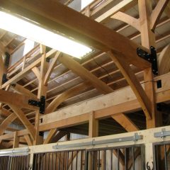 The timber joinery with black hardware is beautiful and will be around for decades to come | Timber Frame Barn | Handcrafted Wood LLC