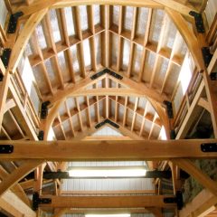 The soaring center aisle with translucent panels allow lots of daylight in Timber Frame Barn | Handcrafted Wood LLC